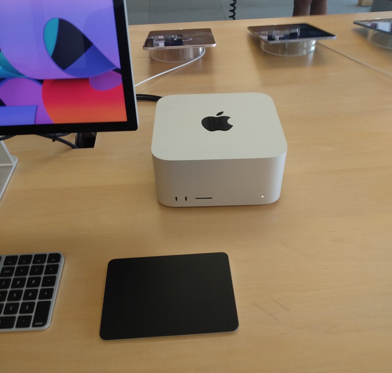 Apple Mac Studio M3 Ultra on display in an Apple Store, showing the recognisable squat aluminium chassis and Apple logo on the top face.